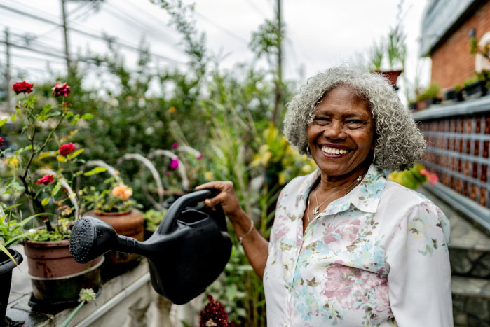 A woman watering plants in a garden